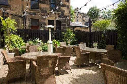 a patio with tables and chairs and a fence at One Devonshire Gardens a Hotel Du Vin in Glasgow