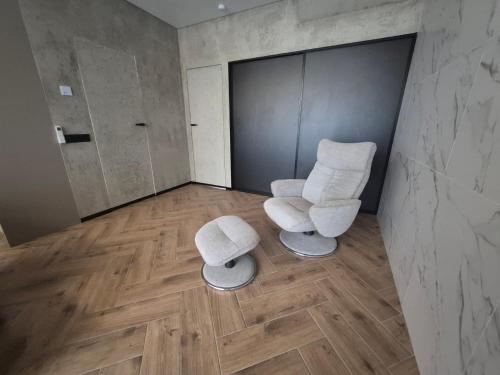 two chairs and two stools in a room at Marių namai in Kaunas
