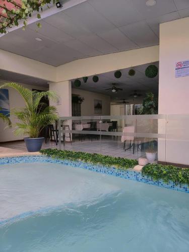 a large swimming pool in a building with a table and chairs at Hotel Sueños in San Salvador