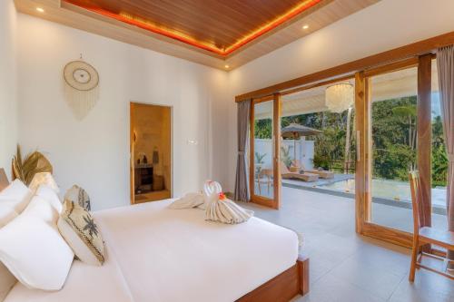 a bedroom with a bed and a view of a pool at Rupa Arya Villa in Ubud