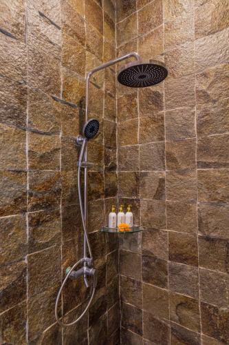 a shower with a shower head in a bathroom at Rupa Arya Villa in Ubud