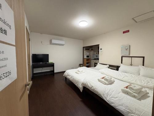 a room with two beds and a television in it at アパート一室堅田駅徒歩10分貸切要相談 in Otsu