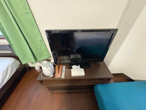 a television on a table in a room with a bed at アパート一室堅田駅徒歩10分貸切要相談 in Otsu