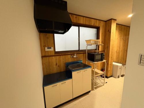 a kitchen with a sink and a microwave at アパート一室堅田駅徒歩10分貸切要相談 in Otsu
