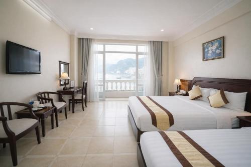 a hotel room with two beds and a television at Hung Long Harbour Hotel in Cat Ba