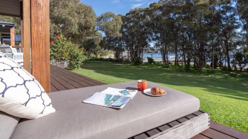 a table with a plate of food on a patio at Tula in Currarong