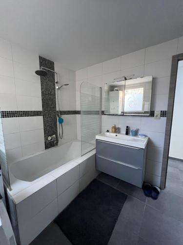 a white bathroom with a tub and a sink at Victoria II Parking GRATUIT in Boussu
