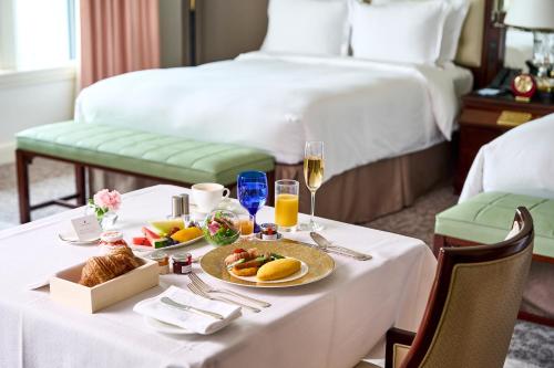 a hotel room with a table with food and drinks at The Ritz-Carlton Osaka in Osaka