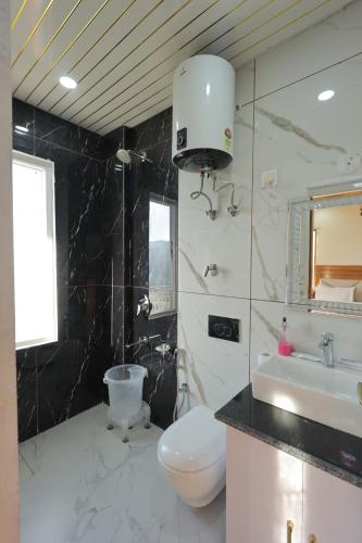 a bathroom with a toilet and a sink at Supreme Sapphire Kufri in Fagu