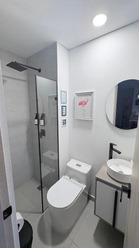 a white bathroom with a toilet and a sink at Citadela Di Sole Tropical Escape in Santa Fe de Antioquia