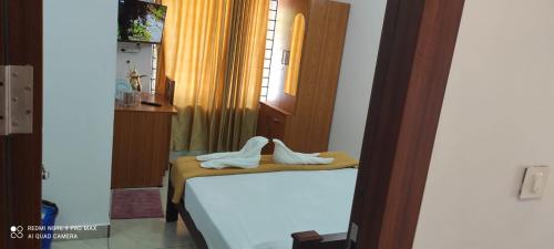 a bedroom with a bed with white shoes on it at Marari A R Residency in Mararikulam