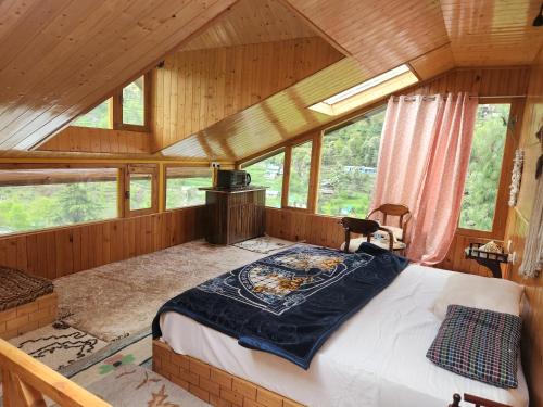 a bedroom with a bed in a room with windows at Avina Heaven in Banjār