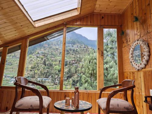 a room with a table and chairs and a large window at Avina Heaven in Banjār