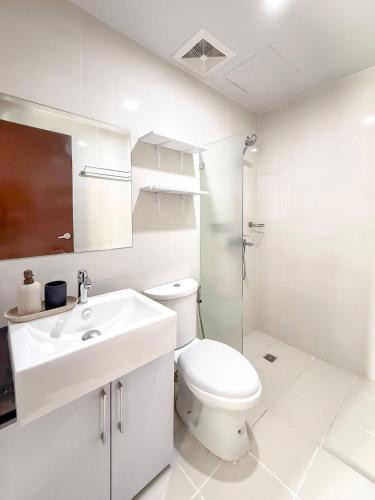 ein weißes Badezimmer mit Toilette und Waschbecken in der Unterkunft The Apartment in Sampong