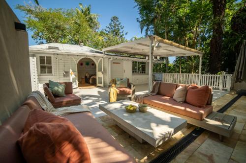a patio with two couches and an umbrella at Vihara - Stunning, Private apartment with private pool in Mullumbimby