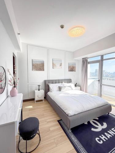 ein weißes Schlafzimmer mit einem großen Bett und einem Schreibtisch in der Unterkunft The Apartment in Sampong