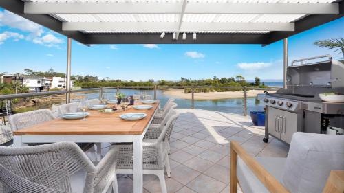 a patio with a table and chairs and a grill at Warrahwillah in Currarong