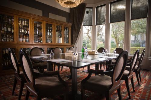a dining room with a table and chairs and windows at One Devonshire Gardens a Hotel Du Vin in Glasgow