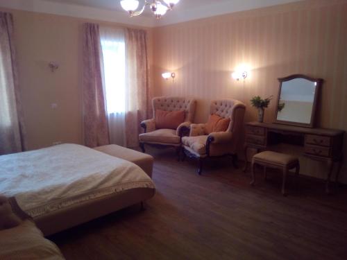 a hotel room with a bed and chairs and a mirror at Meždzirnas Country House & SPA in Kabile