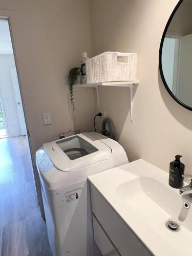 a laundry room with a washer and a sink at Mapua Village Modern Studio in Mapua