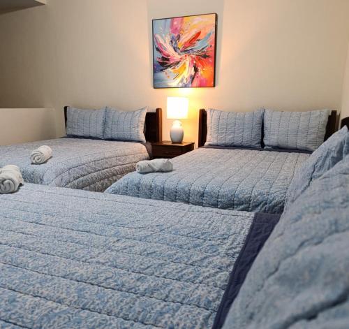 a room with two beds and a table with a lamp at Hotel Sueños in San Salvador