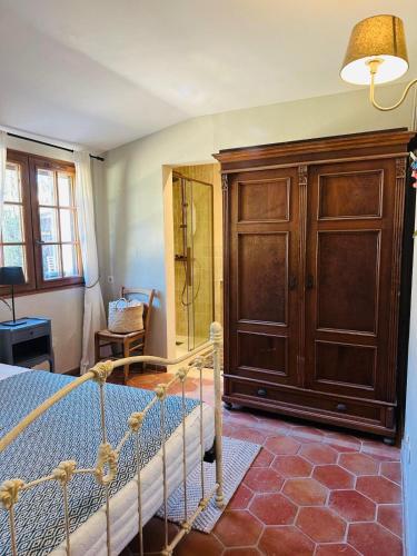 sypialnia z łóżkiem i drewnianą szafką w obiekcie Villa Libellule w mieście Cotignac