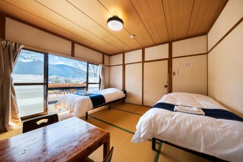 a room with two beds and a table and a window at ホテル 木綿恋記 -Hotel Yufugoiki- in Yufu