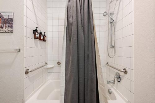 a bathroom with a shower and a tub and a sink at Riverwalk Pool View Condo Pets Free Parking in San Antonio