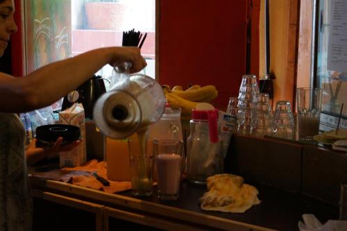 een persoon maakt een drankje in een blender bij Hostel Casagrande in Mar del Plata