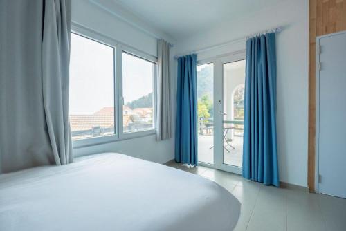 a bedroom with a bed and a large window at 남해독일마을드레스덴 in Samhwa-dong