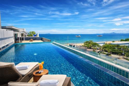 a swimming pool with a view of the ocean at Sunday Beachfront View Jomtien Pattaya in Jomtien Beach