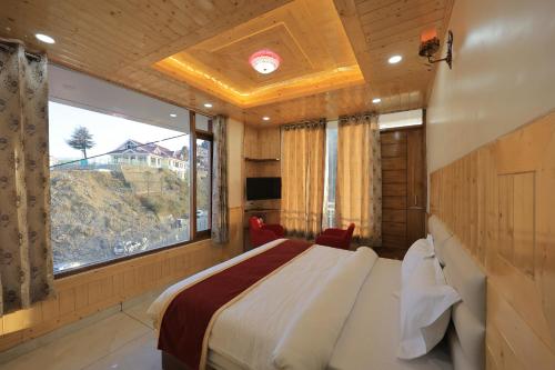 a bedroom with a bed and a large window at Supreme Sapphire Kufri in Fagu