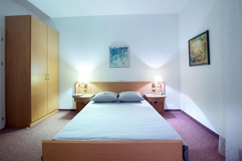 ナーベレジヌイェ・チェルヌイにあるHotel Swiss Houseのベッドルーム1室(ベッド1台、ナイトスタンド2つ、ランプ2つ付)