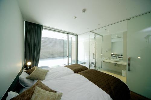 a bedroom with a large bed and a large window at Four Seasons Yuzawa Quattro in Yuzawa