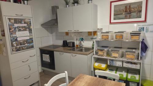 a kitchen with white cabinets and a table in it at Traditional Piran house in Piran