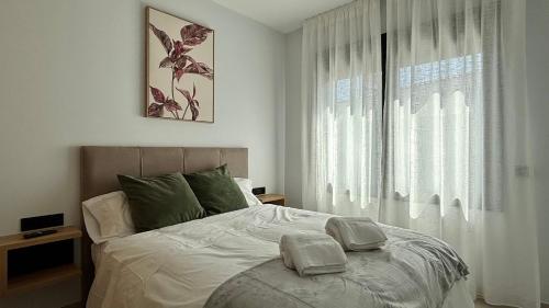 a bedroom with a bed and a large window at Atrio Homes Sansueña in Córdoba