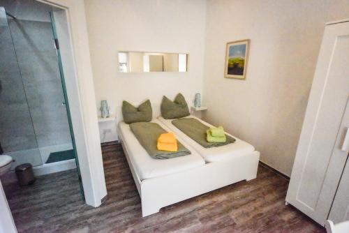 a white bed in a room with a shower at Bootshaus Pritzerbe in Kützkow