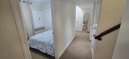 a hallway leading to a bedroom with a bed at Cozy Basement Suite in Lower Sackville