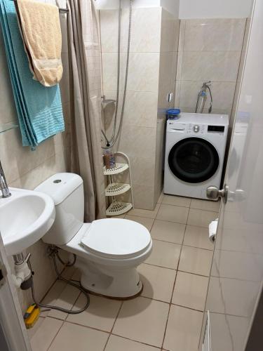 a bathroom with a toilet and a washing machine at Studio condo oceanside - pools, gym, mini market in Dao