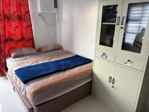 a small bedroom with a bed and a cabinet at Studio condo oceanside - pools, gym, mini market in Dao
