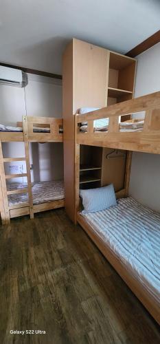 two bunk beds in a room with wooden floors at Jarasum Guest House in Gapyeong