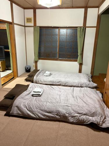 two beds in a room with a large bedvisor at オホーツクハウスえんがる in Engaru