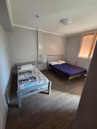 a bedroom with two beds and a window at Le Bel Air - Decize in Decize