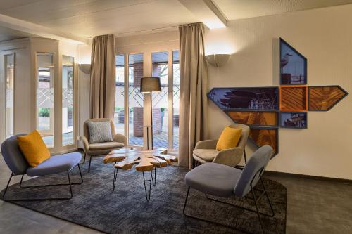 a living room with chairs and a table at Four Points Flex by Sheraton Kiel in Kiel