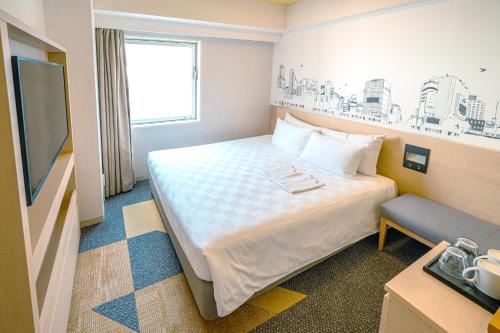 a hotel room with a bed and a tv at Shibuya Tokyu REI Hotel in Tokyo