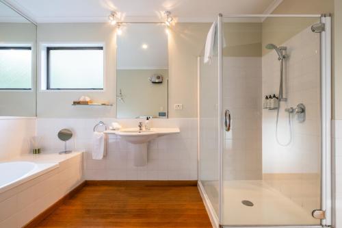 a bathroom with a sink and a tub and a shower at Hidden Lodge Queenstown in Queenstown