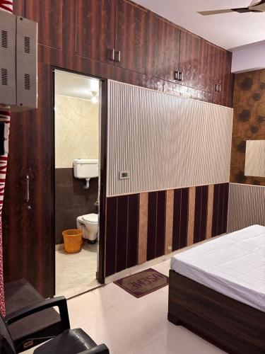 a room with a bed and a bathroom with a toilet at Absolute hostel in Meerut