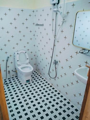 a bathroom with a toilet and a sink with stars on the wall at KOHRONG khmerhome in Kaôh Rŭng (3)