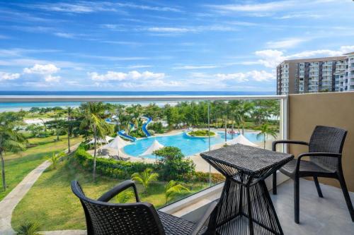 a balcony with a table and chairs and a view of the ocean at Solea Seaview Resort in Mactan