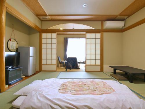 a room with a bed and a table in it at おばな旅館 富貴亭 in Nagano